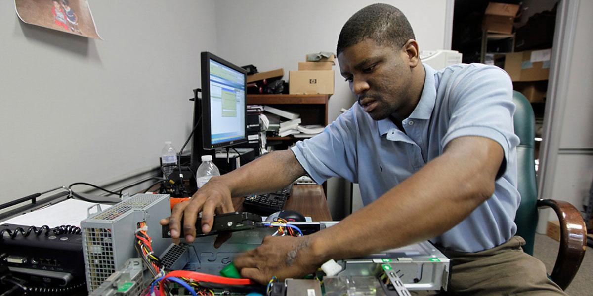 Student works on the inside of a computer.